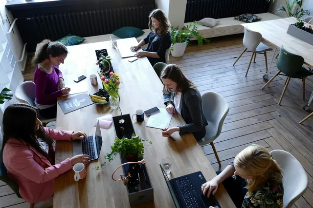 Une réunion de travail autour d’une table en bois.